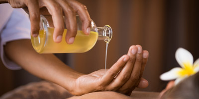 therapist-pouring-massage-oil-spa