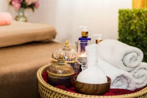 Traditional Arabic massage setup with herbal compress, rolled white towels, aromatic oils, and decorative spa containers at Carval Health Spa in Business Bay, Dubai.