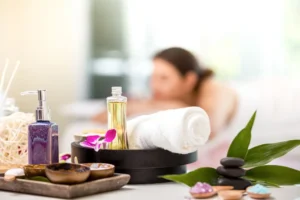 Swedish massage setup with essential oils, rolled towels, hot stones, and orchid.